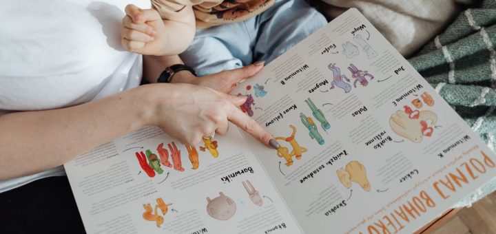 A comforting moment of a mother reading a colorful picture book with her child.