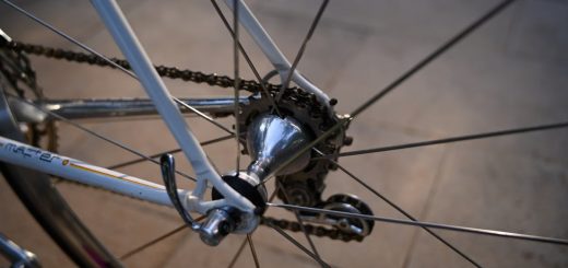 Detailed view of a bicycle's rear wheel with focus on the hub and chain in daylight.